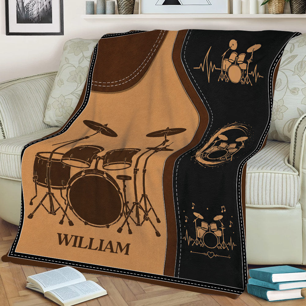 Drum blanket draped over a couch featuring drum kits, musical notes and heartbeat lines