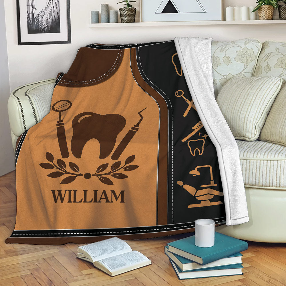 Dentist blanket displayed on a sofa with tooth and dental instrument artwork in brown and black