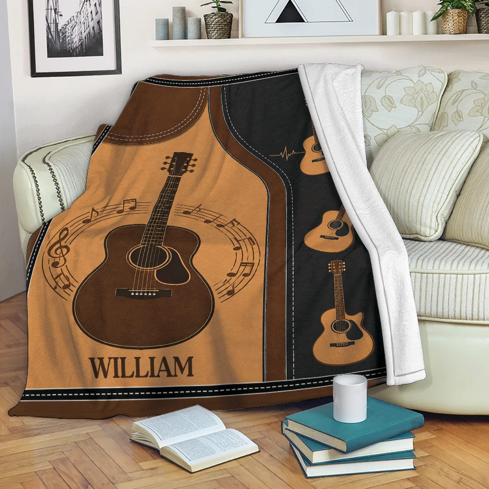 Guitar throw blanket displayed across a sofa with acoustic guitar artwork and musical notes