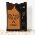Tennis throw blanket featuring crossed racquets, tennis balls, and court artwork in orange, brown, and black