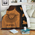Sheep throw blanket draped over a sofa, showing rustic animal artwork in warm brown and black tones