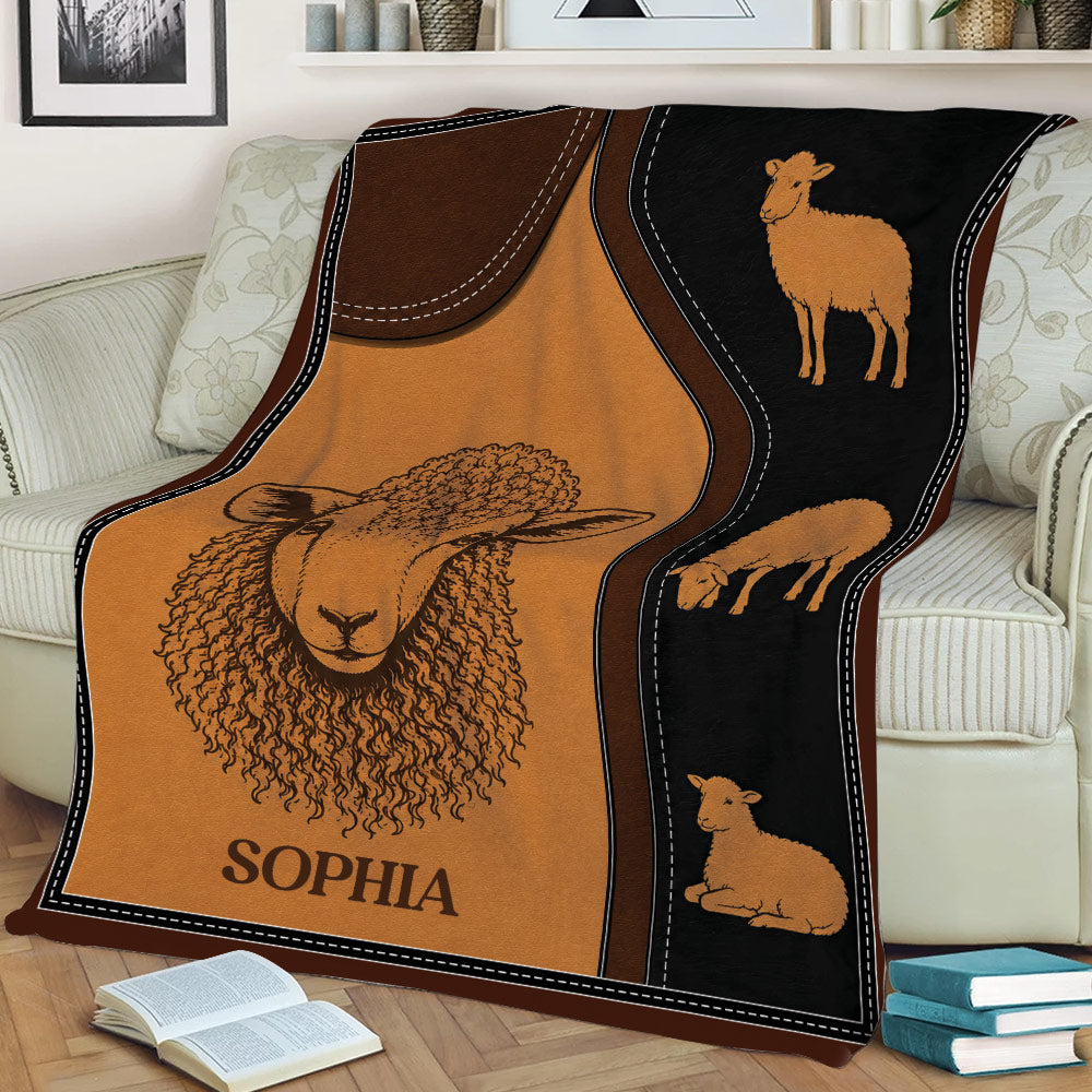 Illustrated sheep blanket displayed on a couch with a large sheep portrait and coordinating lamb designs