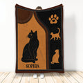 Black cat blanket with orange and brown artwork, paw print motif, and decorative cat silhouettes
