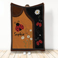 Ladybug throw blanket displayed with red ladybugs, daisies, and brown and black garden-inspired artwork