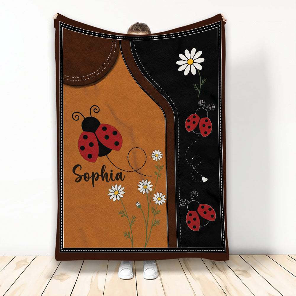 Ladybug throw blanket displayed with red ladybugs, daisies, and brown and black garden-inspired artwork