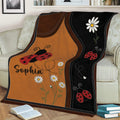 Ladybug throw blanket styled on a couch with playful insects, daisies, and contrasting brown and black panels
