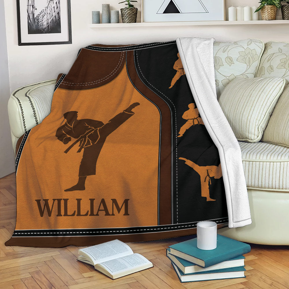 Karate blanket draped over a sofa with kicking martial artist silhouettes and bold orange and black design