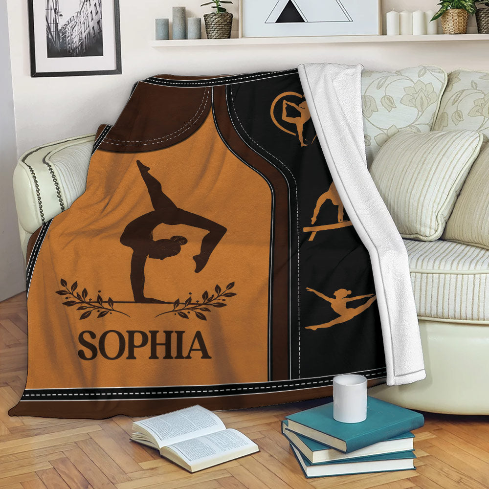 Custom gymnastics blanket draped over a sofa with gymnast silhouettes and balance beam artwork
