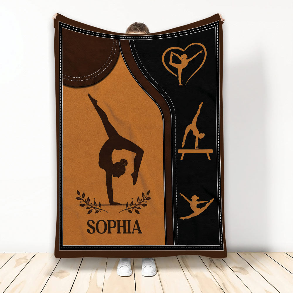 Gymnastics throw blanket featuring silhouetted athletes, a balance beam, heart motif, and warm brown artwork