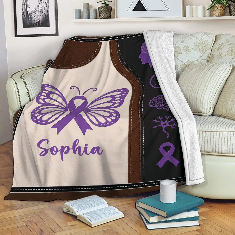 Alzheimer's awareness throw blanket displayed on a sofa with purple ribbon and butterfly artwork