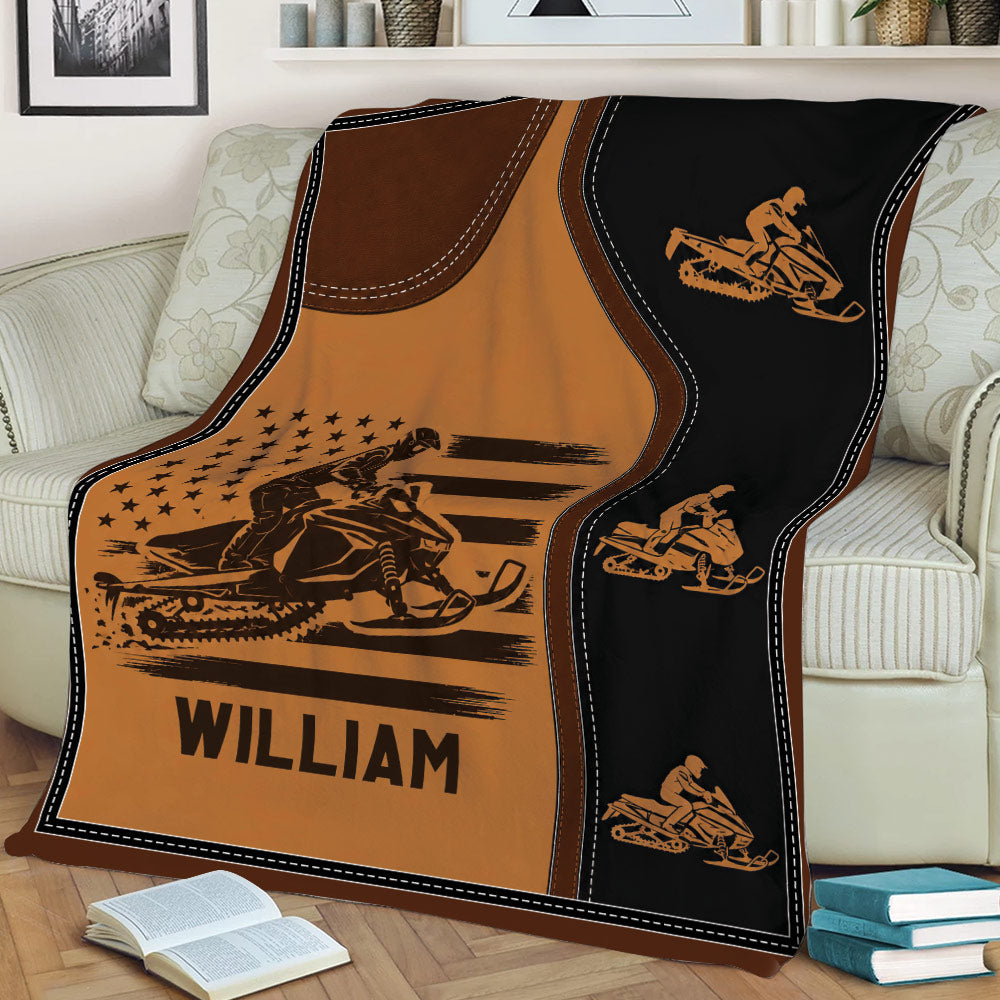 Snowmobile throw blanket draped over a couch featuring multiple rider illustrations and rugged outdoor styling