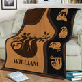 Close lifestyle view of a sloth blanket displayed across a couch with branch and woodland artwork