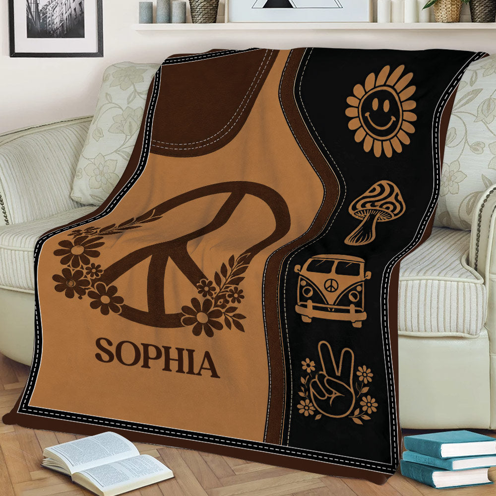 Earthy hippie throw blanket displayed on a couch with peace, flower, mushroom, and vintage van designs