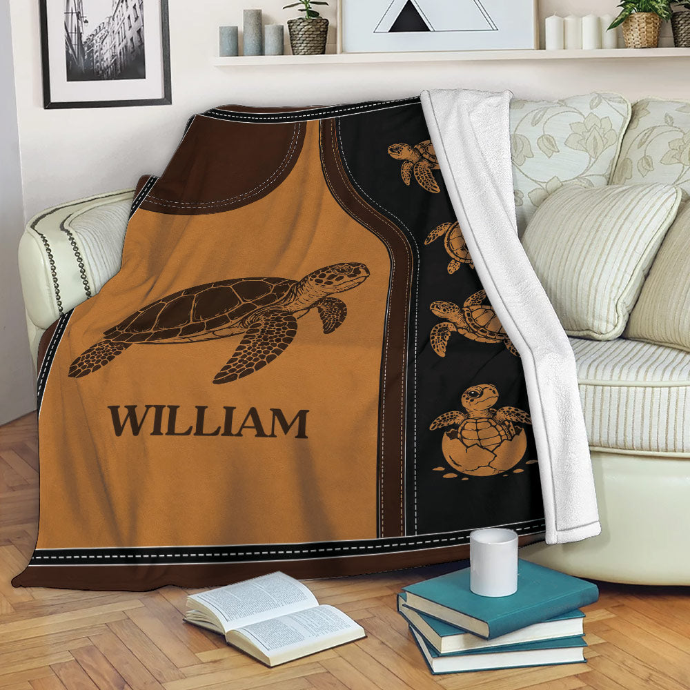 Turtle throw blanket displayed on a sofa with warm sea turtle artwork and dark borders