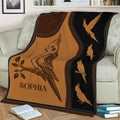 Cockatiel blanket styled across a sofa, featuring vintage sepia bird artwork and a repeating black border panel