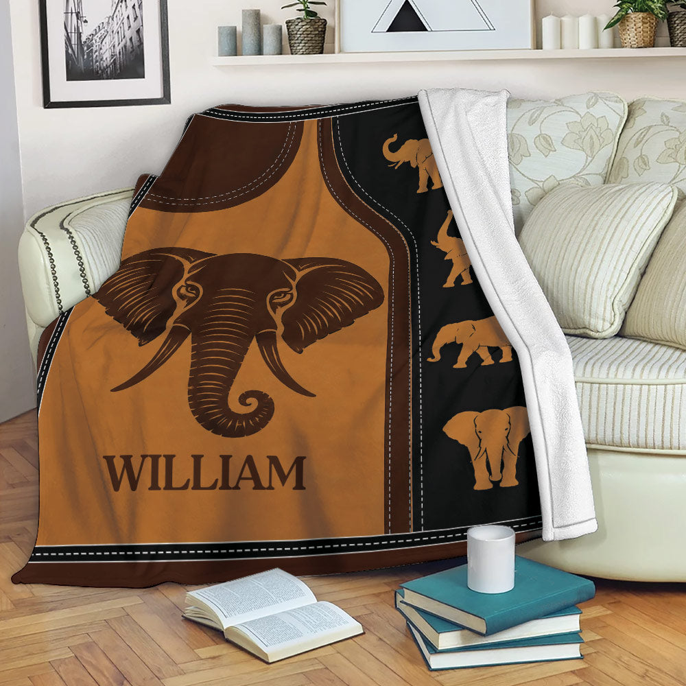 Elephant blanket draped over a sofa with warm earthy artwork and repeated elephant silhouettes