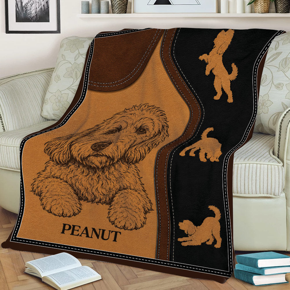 Close view of a Labradoodle throw blanket draped over a couch with illustrated dog motifs