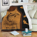 Dolphin blanket draped over a sofa, showing ocean wildlife artwork in warm brown and black tones