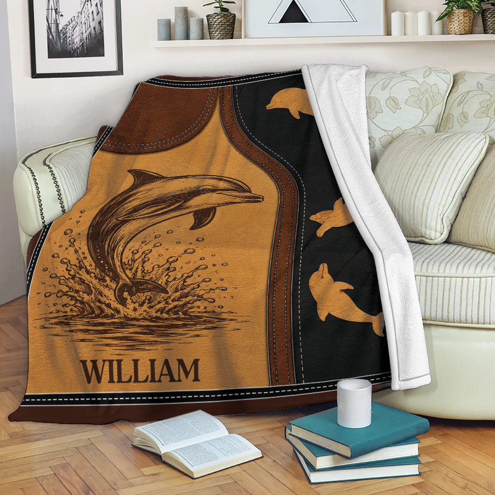 Dolphin blanket draped over a sofa, showing ocean wildlife artwork in warm brown and black tones