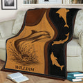 Dolphin throw blanket displayed on a sofa with a leaping dolphin and matching ocean silhouettes