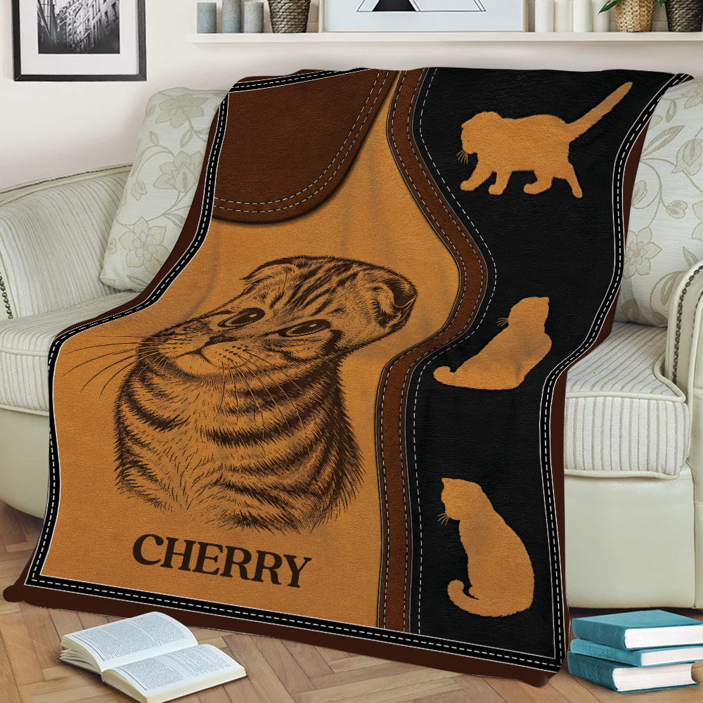 Scottish Fold cat blanket draped over a couch, featuring warm brown and black artwork
