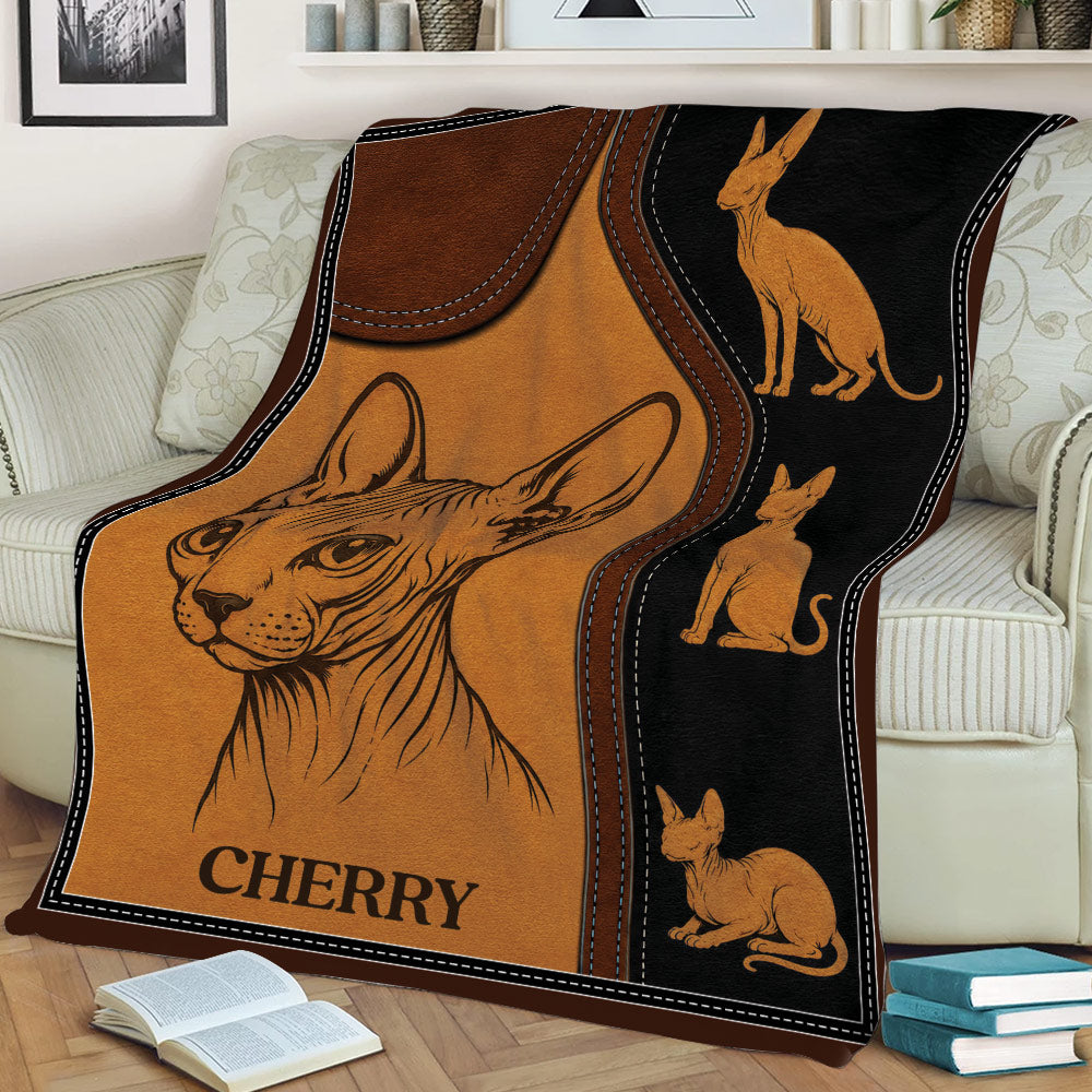 Sphynx cat blanket draped over a couch, featuring a large hairless cat illustration and coordinating cat designs