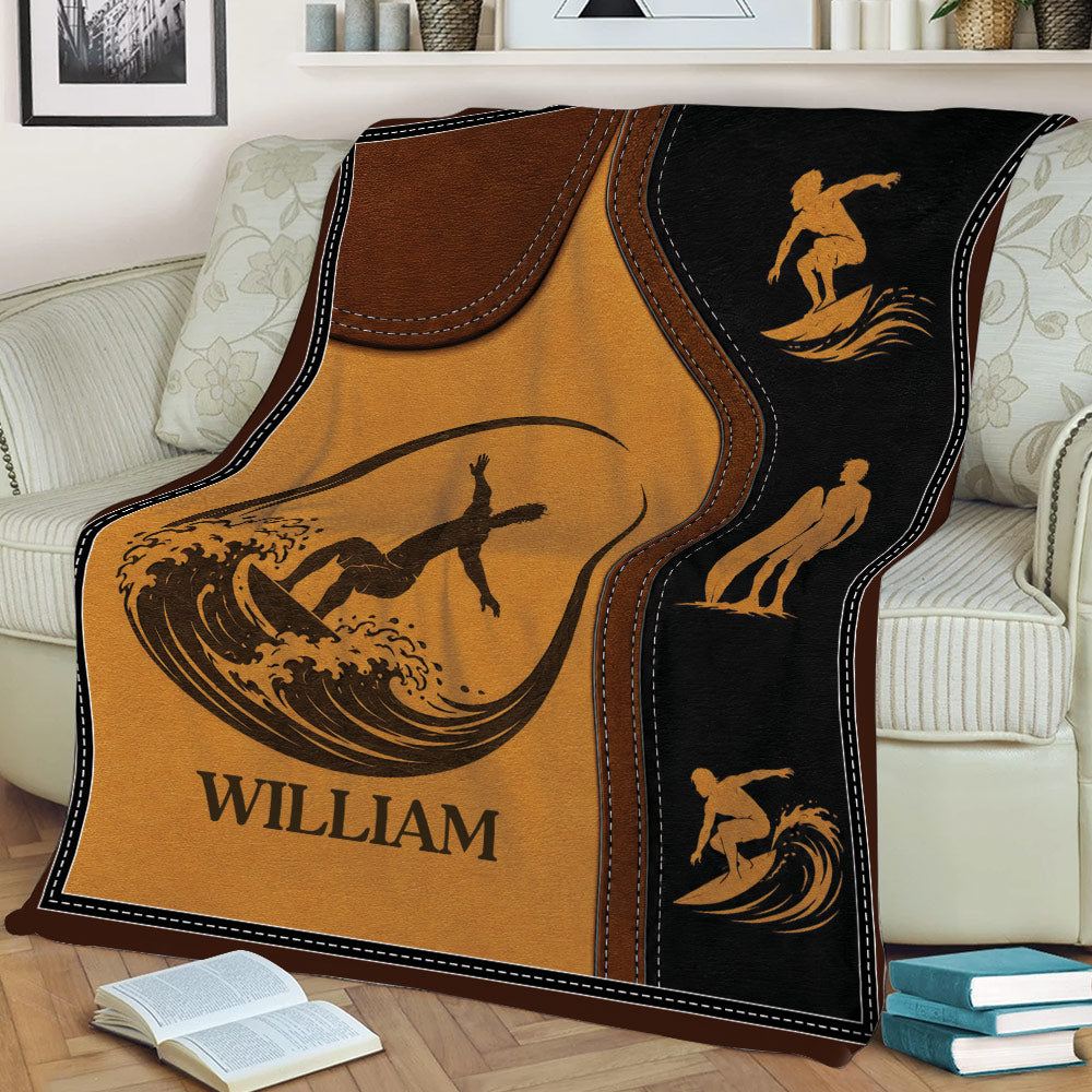Vintage surfing throw blanket displayed on a sofa with surfer silhouettes, waves, and surfboard artwork