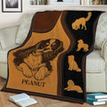 Cavalier King Charles blanket displayed on a couch with illustrated dog poses and rustic styling
