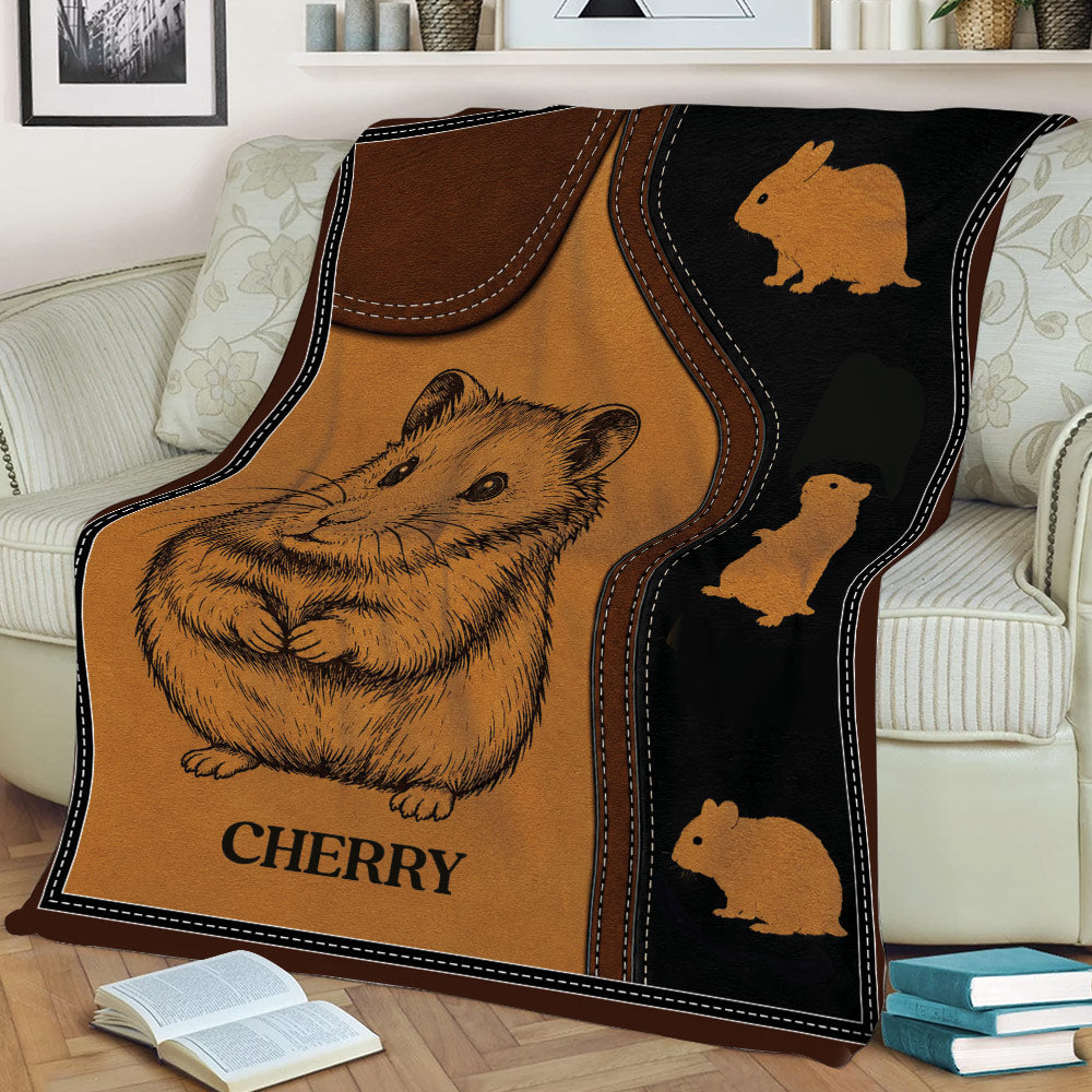 Hamster blanket styled across a couch, featuring a large illustrated hamster and warm brown tones