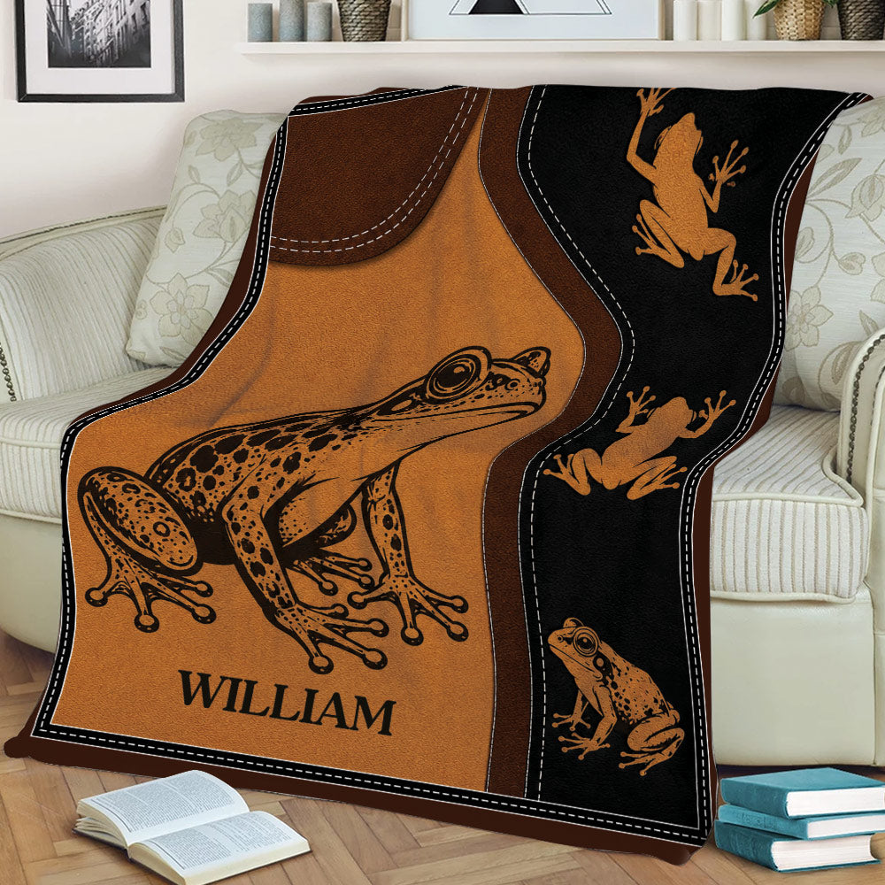 Frog throw blanket styled across a sofa, featuring a large illustrated frog and smaller frog silhouettes