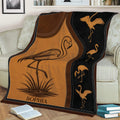 Flamingo blanket draped over a couch, featuring a large wading bird and repeating flamingo silhouettes