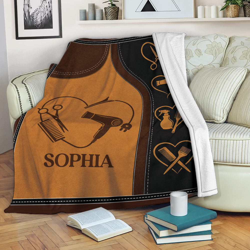 Hairstylist throw blanket displayed on a sofa with scissors, combs, brushes, and blow dryer artwork