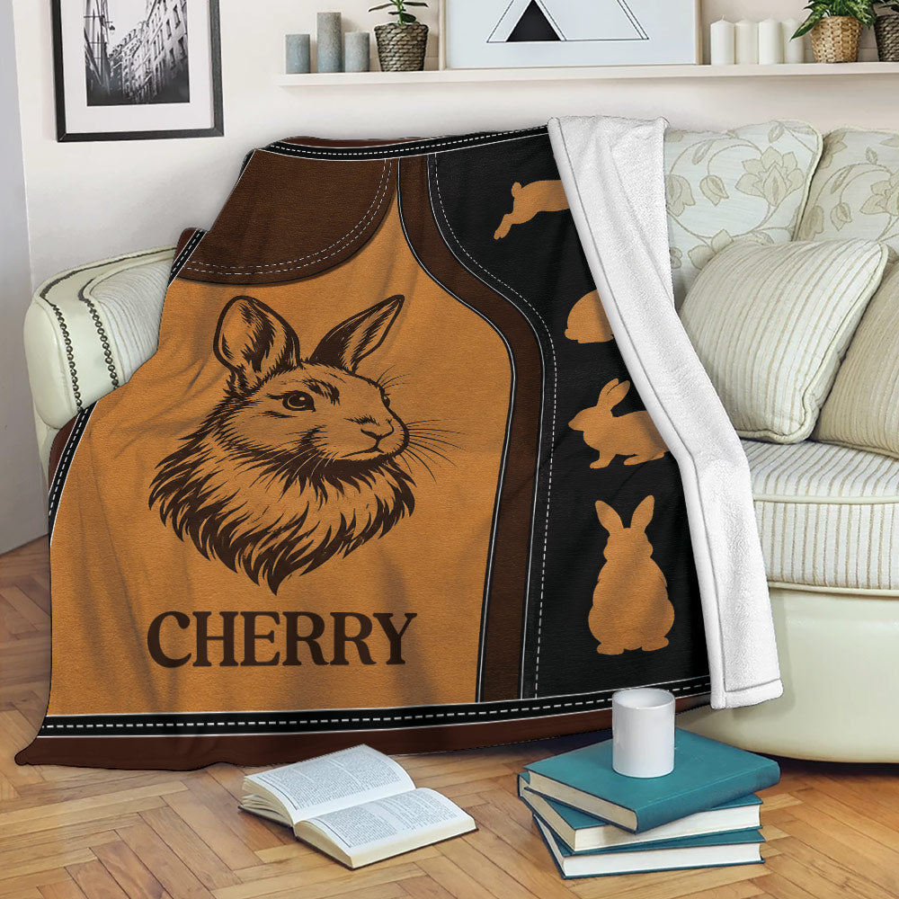 Rustic rabbit throw blanket draped over a sofa, showing a detailed bunny illustration and repeating rabbit silhouettes