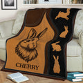 Rabbit blanket styled across a sofa with warm brown artwork, black accents, and illustrated bunny silhouettes