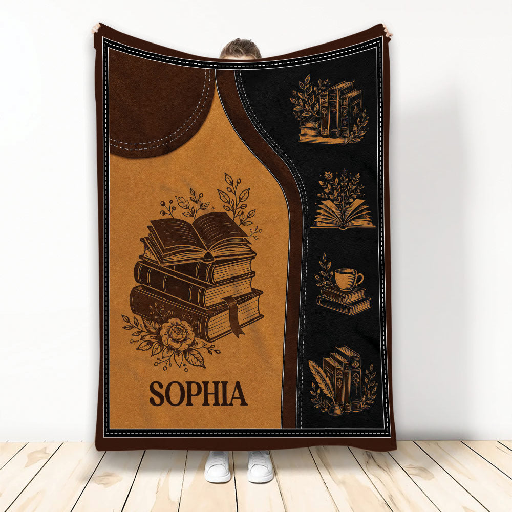 Book-themed blanket with stacked books, open pages, flowers, and warm brown library-inspired artwork