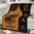 Literary throw blanket displayed on a couch with open books, stacked books, flowers, and reading details