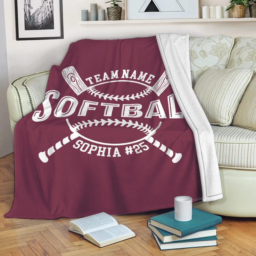 Maroon softball blanket draped over a sofa in a cozy living room with crossed bat artwork