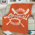 Orange softball blanket spread across a sofa with crossed bats and white softball artwork