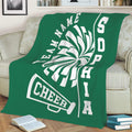 Green cheerleading throw blanket draped over a sofa with pom-pom and megaphone design