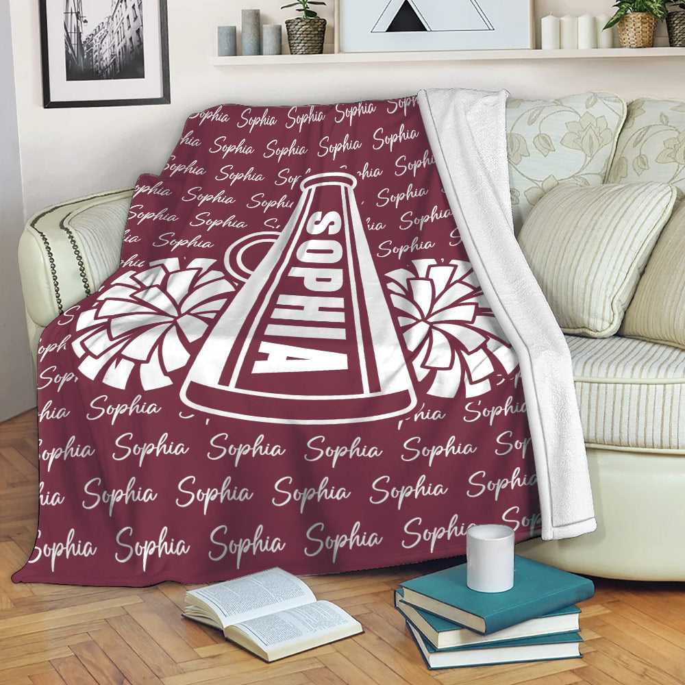 Cheerleading throw blanket styled on a sofa with a megaphone and pom-pom artwork