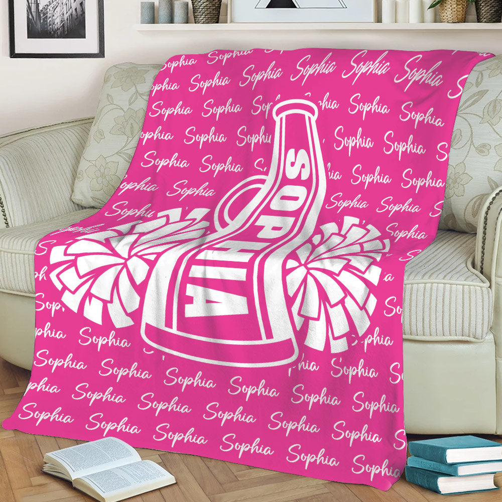 Pink cheerleading throw blanket displayed on a sofa with bold megaphone artwork