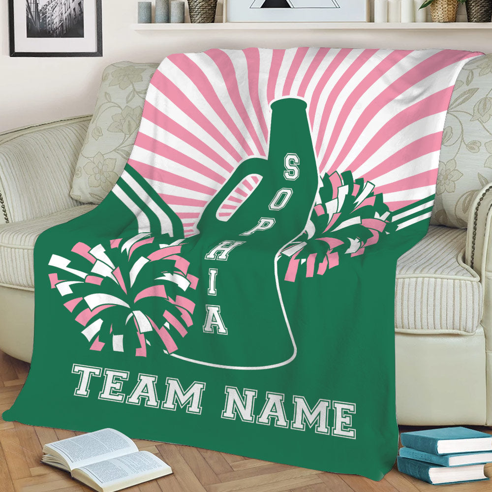 Green and pink cheerleading throw blanket shown on a sofa with megaphone and pom pom artwork