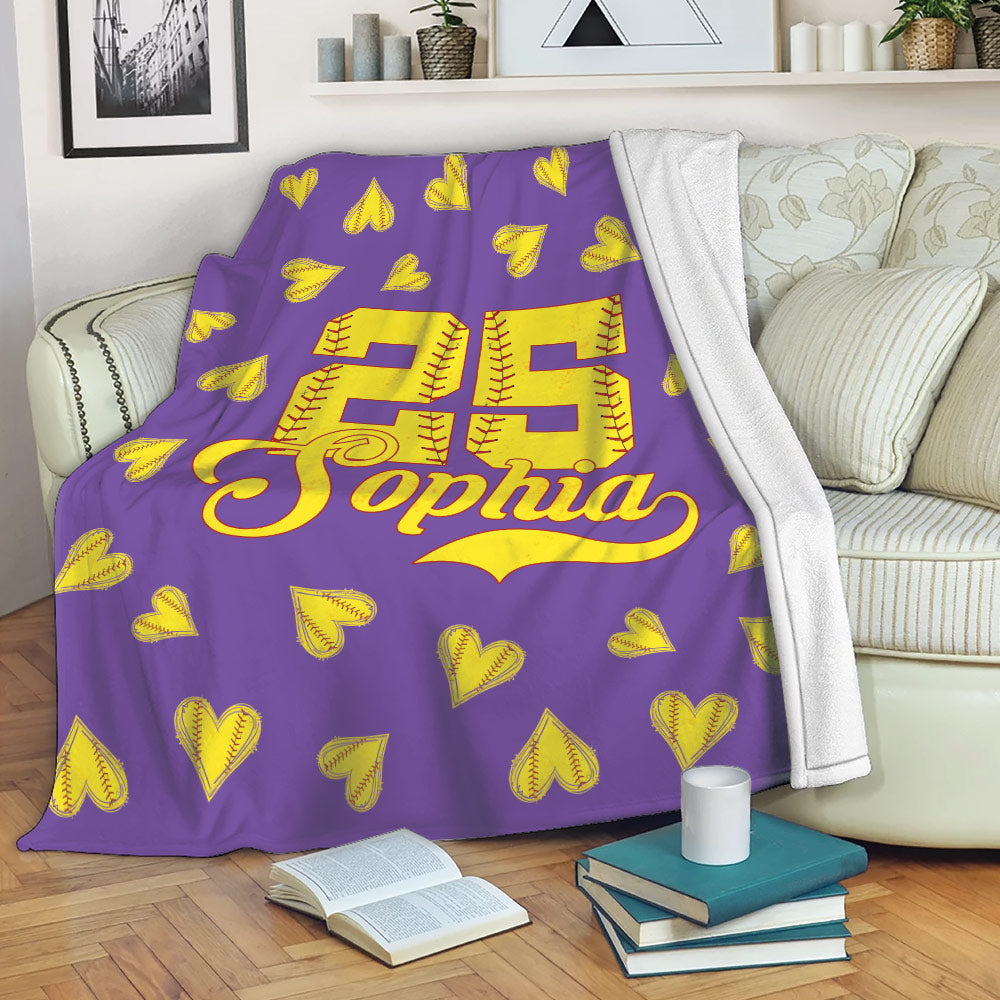 Softball throw blanket displayed on a sofa with yellow stitched hearts and a bold jersey-style sports design
