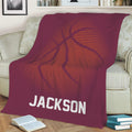 Maroon basketball throw blanket styled on a sofa with bold orange sports artwork
