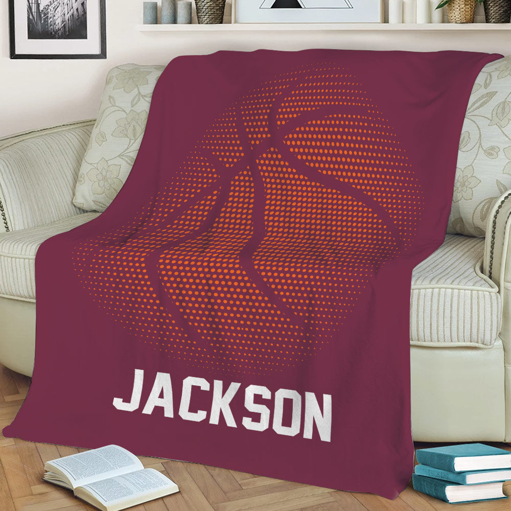 Maroon basketball throw blanket styled on a sofa with bold orange sports artwork