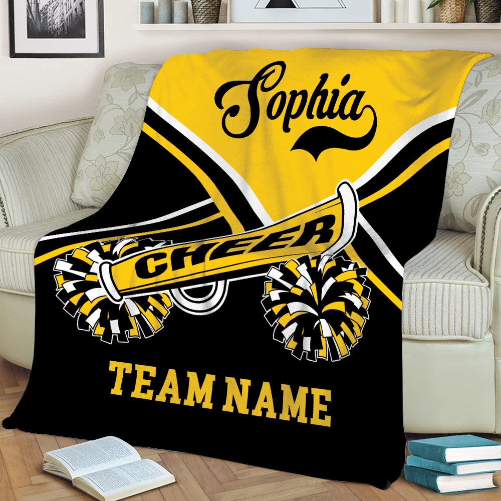 Yellow and black cheerleading throw blanket styled on a sofa with spirited pom-pom artwork