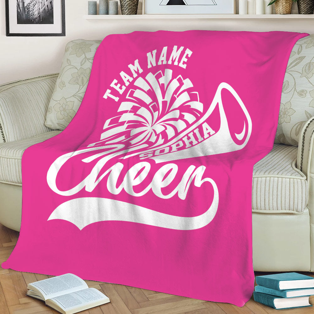 Bright pink cheerleading blanket draped over a sofa with energetic white sports artwork