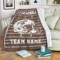 Brown football throw blanket draped over a sofa with field lines and bold helmet artwork