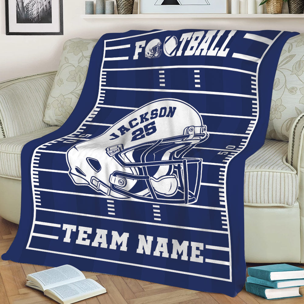 Navy football throw blanket styled on a sofa with field markings and large helmet artwork