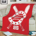 Red baseball throw blanket draped over a sofa with bold crossed bat and baseball emblem artwork